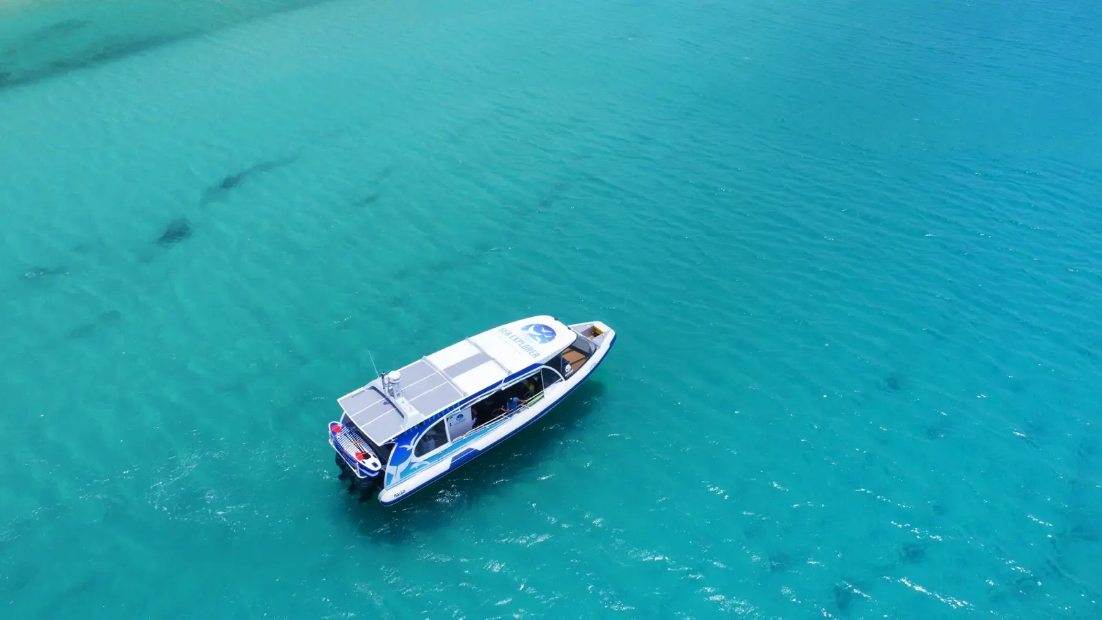 Aerial view of a catamaran cruising turquoise Whitsundays water